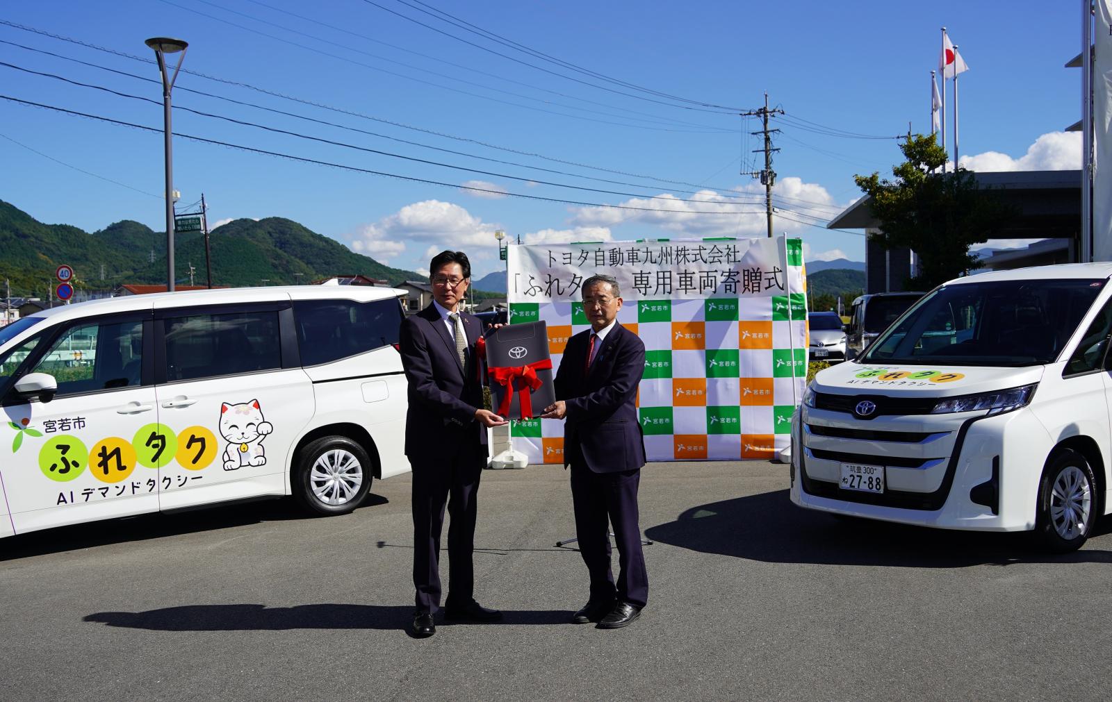 寄贈車両のレプリカキーを手にする塩川市長と原田本部長（左）